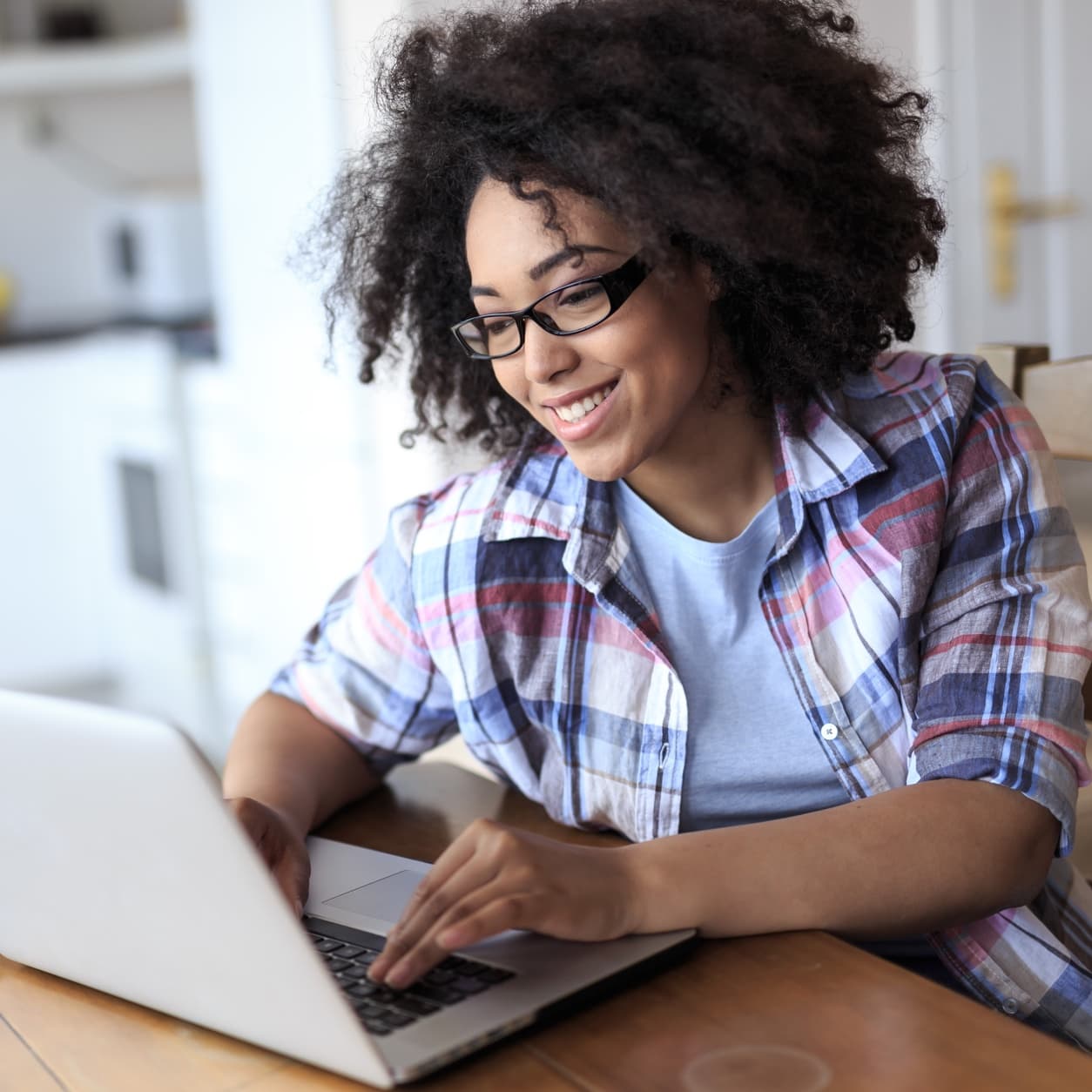 Woman reading on her laptop at a kitchen table