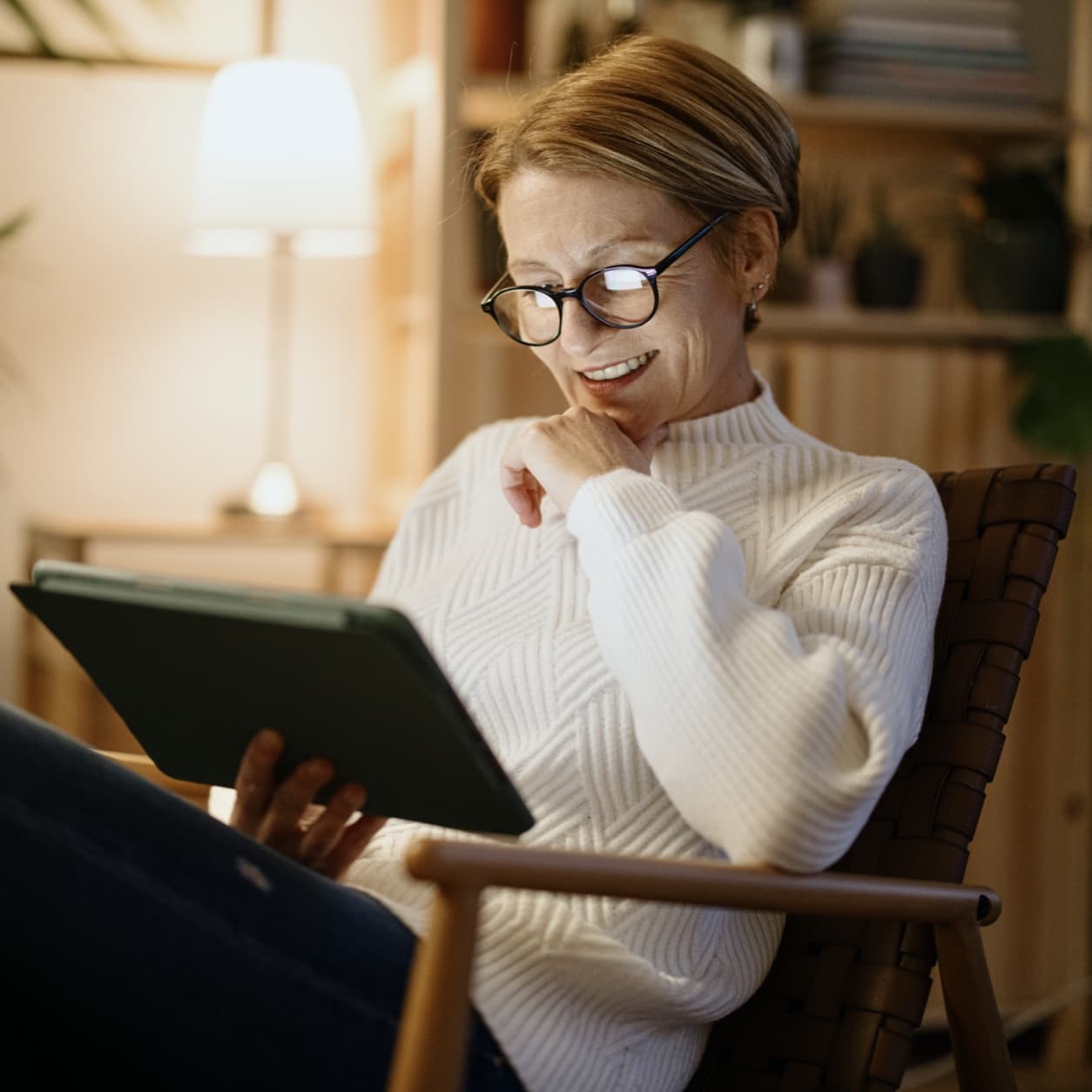 Woman reading on a tablet in a softly lit living room