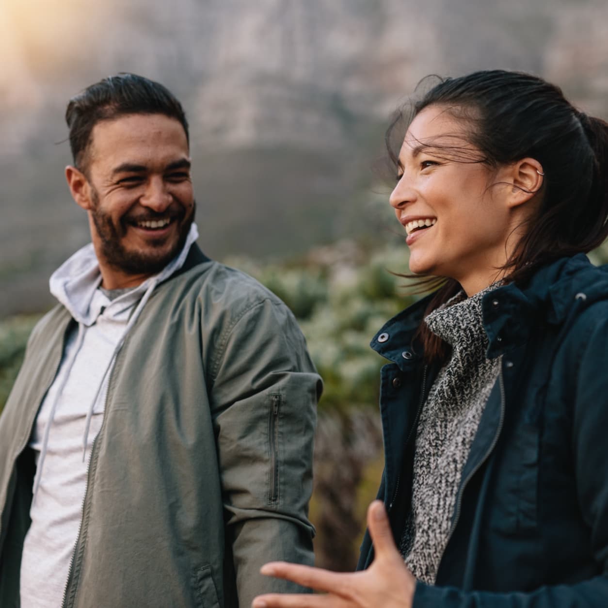 Couple laughing together on a mountain trail